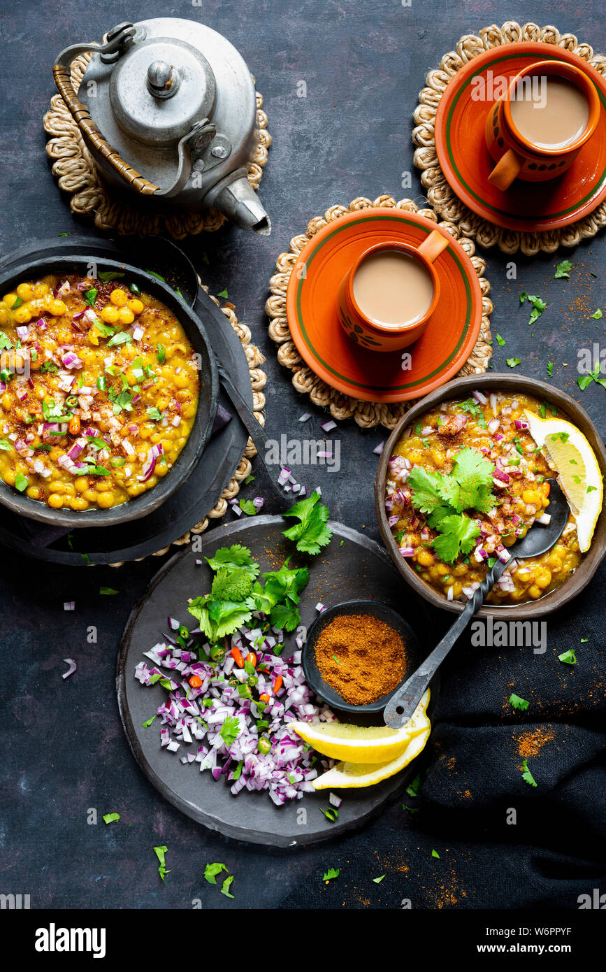 Curry de lentilles vegan indien servi avec de l'oignon haché, la coriandre, Les chiles verts , de la terre fraîche et d'épices chai fraîchement préparés. Banque D'Images