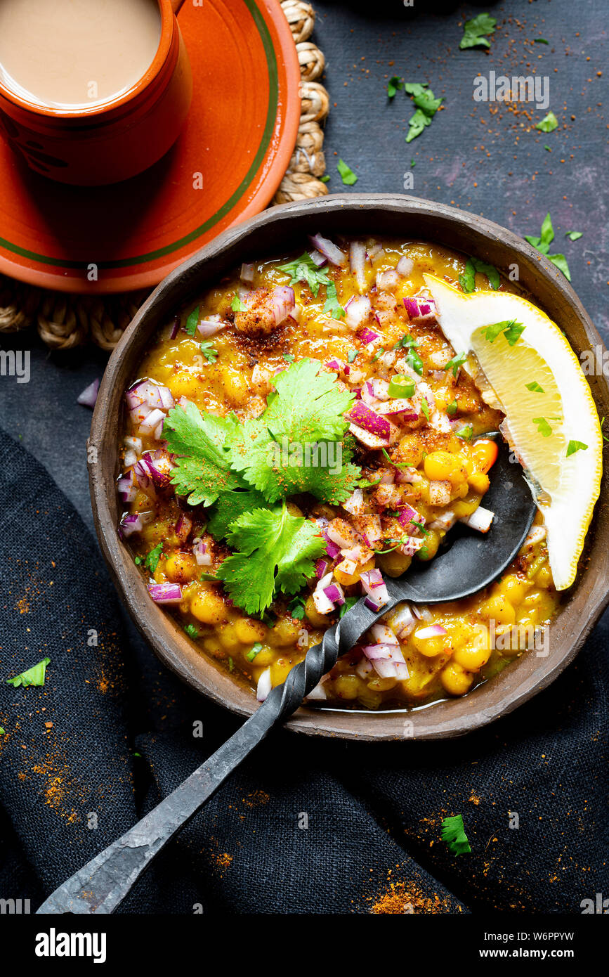 Curry de lentilles vegan indien servi avec de l'oignon haché, la coriandre, Les chiles verts , de la terre fraîche et d'épices chai fraîchement préparés. Banque D'Images