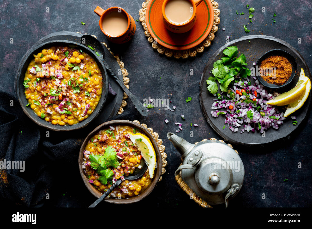 Curry de lentilles vegan indien servi avec de l'oignon haché, la coriandre, Les chiles verts , de la terre fraîche et d'épices chai fraîchement préparés. Banque D'Images