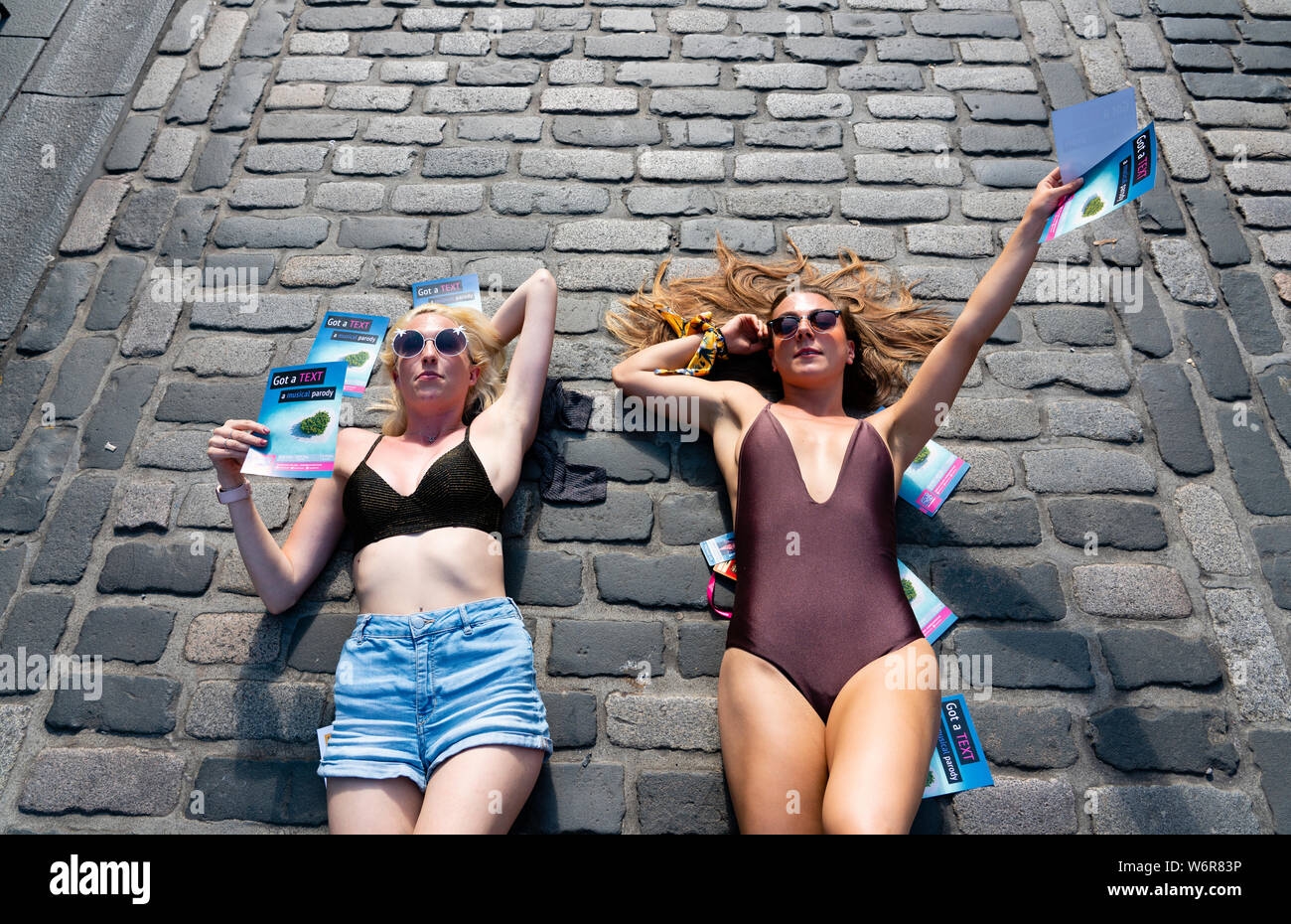 Edinburgh, Ecosse, Royaume-Uni. 2 Août, 2019. Le jour de l'ouverture de l'Edinburgh Festival Fringe ces deux jeunes femmes étaient en train de bronzer sur le Royal Mile et distribuer des flyers pour leur montrer un texte : une parodie musicale Crédit : Iain Masterton/Alamy Live News Banque D'Images