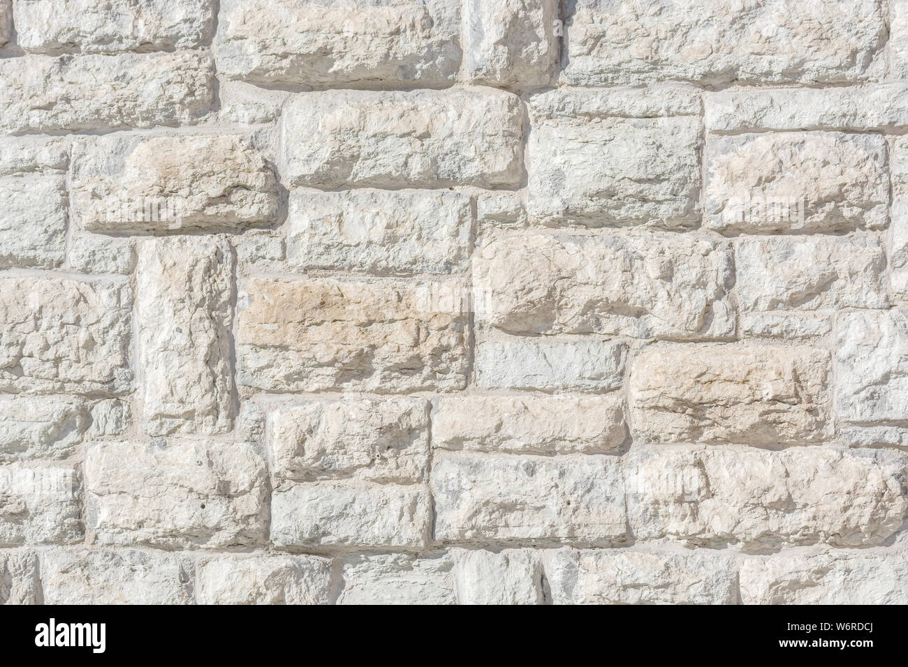 Fragment de lumière d'un vieux mur de blocs de pierre calcaire pour l'utiliser comme un fond abstrait et la texture. Banque D'Images