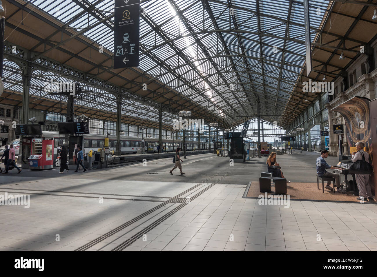 Les trains aux plates-formes dans Tours, France, ancienne station de train - Gare de Tours - construit en 1898. À l'aide de la pianiste libre d'utiliser le piano droit, avec l'auditoire. Banque D'Images