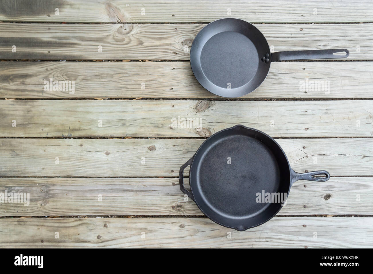 Fonte d'acier au carbone vs vs casseroles en téflon. Poêle de cuisine bataille pour comparaison options de cuisson plus saine de cuisinière à four à feu de camp. Vide Vide Banque D'Images