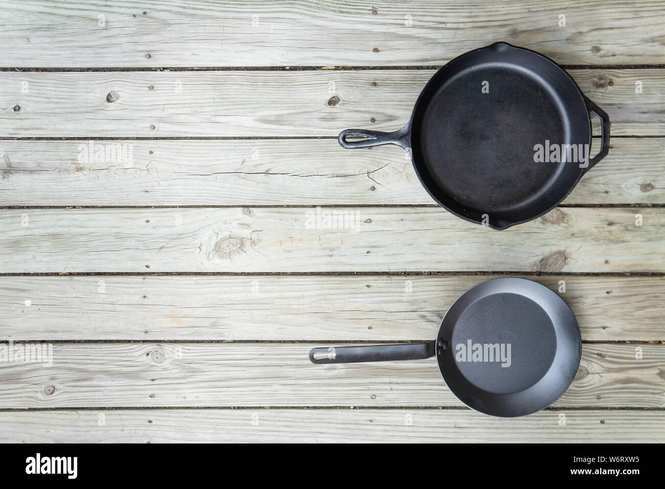 Fonte d'acier au carbone vs vs casseroles en téflon. Poêle de cuisine bataille pour comparaison options de cuisson plus saine de cuisinière à four à feu de camp. Vide Vide Banque D'Images