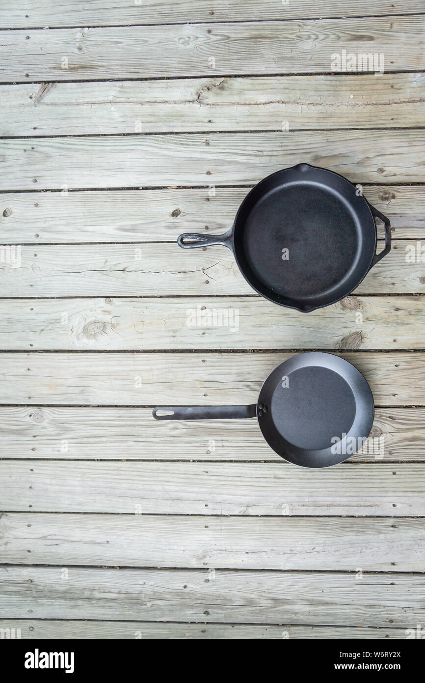 Fonte d'acier au carbone vs vs casseroles en téflon. Poêle de cuisine bataille pour comparaison options de cuisson plus saine de cuisinière à four à feu de camp. Vide Vide Banque D'Images