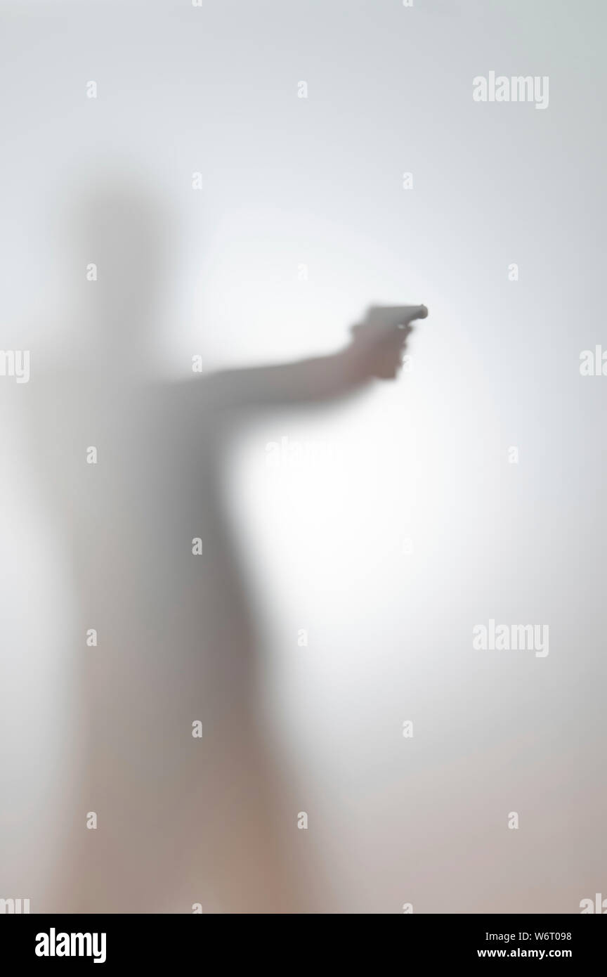 Troubles de silhouette d'un homme avec une arme à feu. Banque D'Images