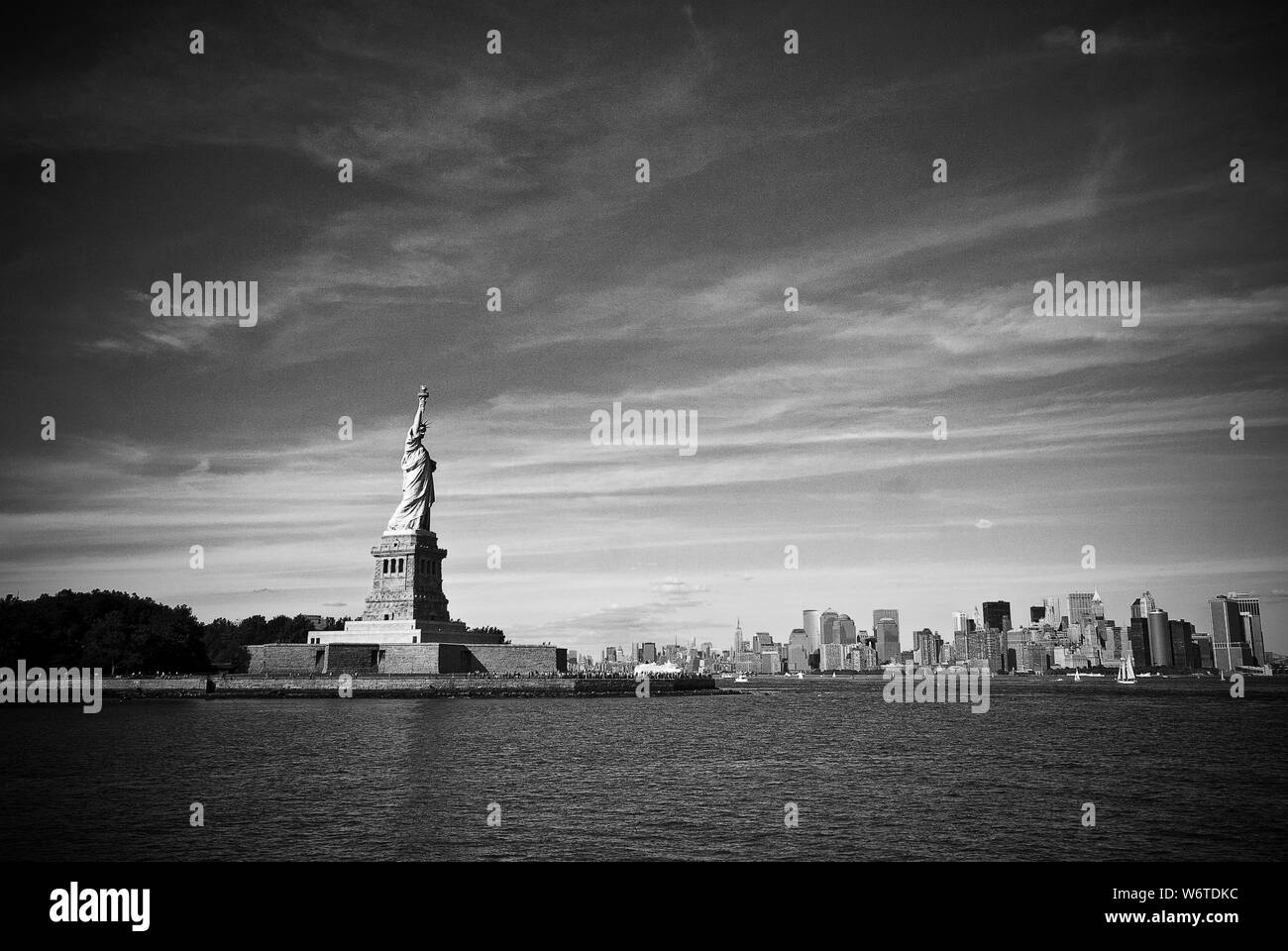 La Statue de la liberté s'élève au-dessus du port de New York avec le Lower Manhattan (New York) skyline en arrière-plan. Banque D'Images