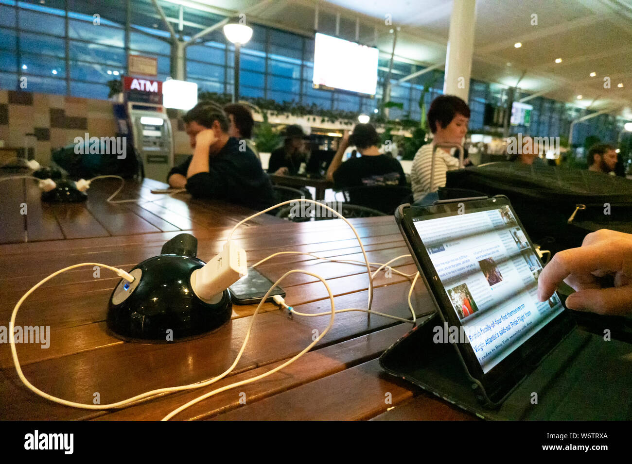 Les voyageurs utilisant une station de recharge de l'aéroport de Brisbane, Terminal International, Queensland, Queensland, Australie Banque D'Images