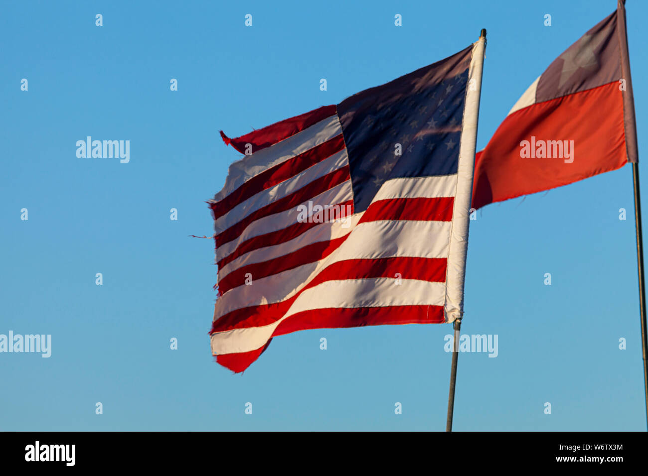 D'effilochement ancien drapeau des États-Unis d'Amérique contre un ciel bleu avec un drapeau du Chili derrière elle Banque D'Images