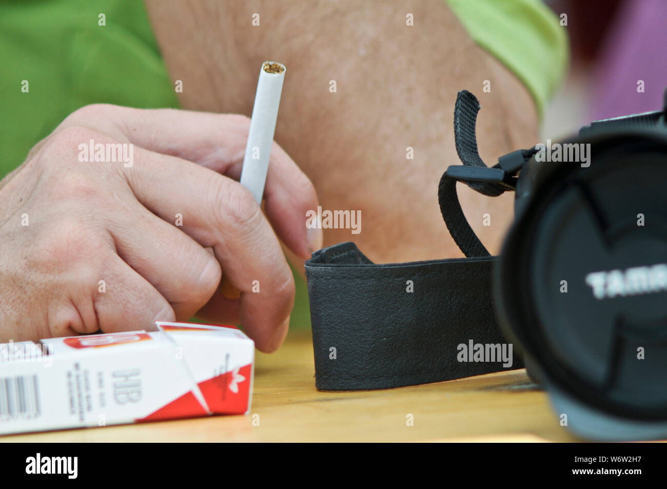 La main de l'homme avec une cigarette et un appareil photo Banque D'Images