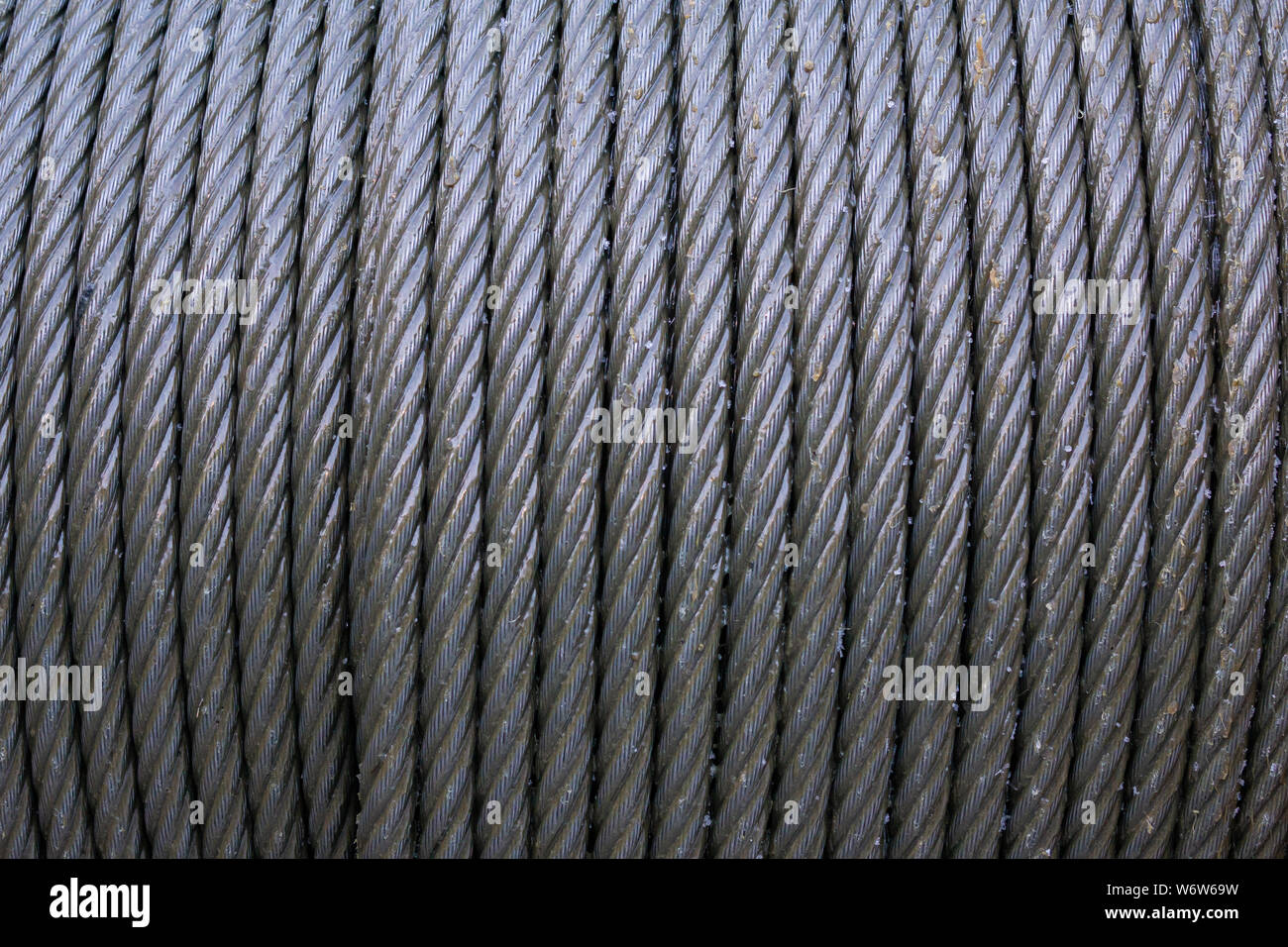 L'élingue de câble métallique ou grue élingue de câble sur tambour tambour de treuil ou rouleau de la grue Levage de la machine dans l'industrie lourde. câble d'acier. corde métal texture. Banque D'Images