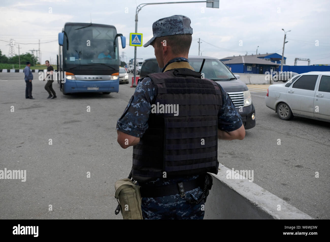 Un policier armé portant une veste de protection en flanelle se tient au poste de contrôle de Malka à la frontière entre Stavropol Krai et la République Kabardino-Balkar dans le district fédéral du Caucase du Nord de Russie. Banque D'Images
