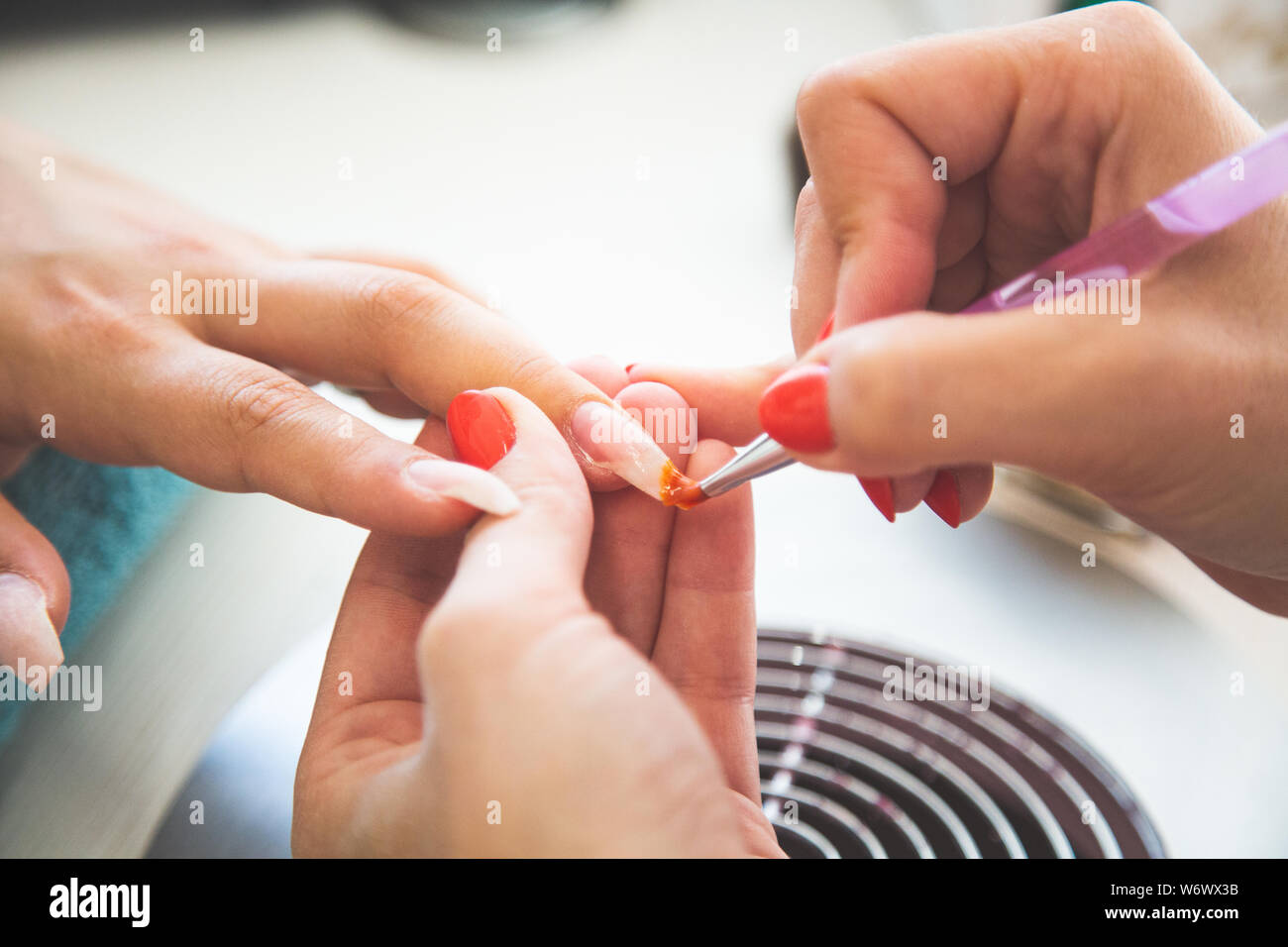 Libre de manucure nail polish Gel s'applique sur le doigt. Girl client détient la main sur le client sur une serviette. Services manucurés doucement coiffeur Banque D'Images