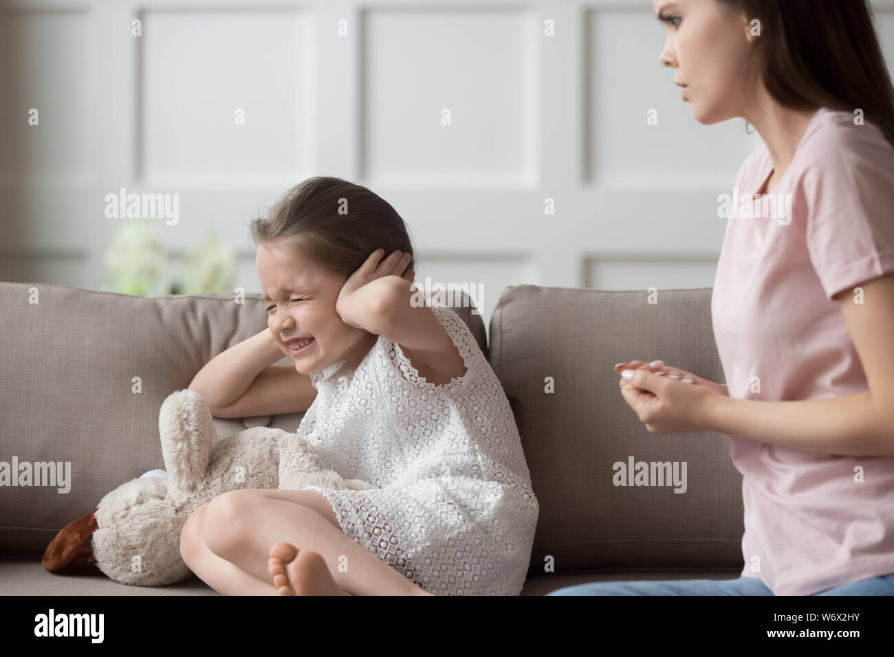 Vilain petit fille fermer ses oreilles écoute pas réprimander les mères Banque D'Images