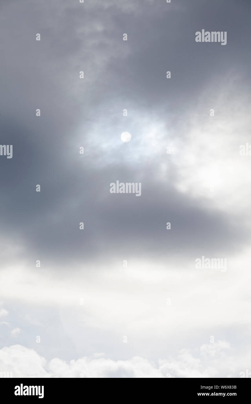 Soleil derrière des nuages gris sur un jour brumeux Banque D'Images