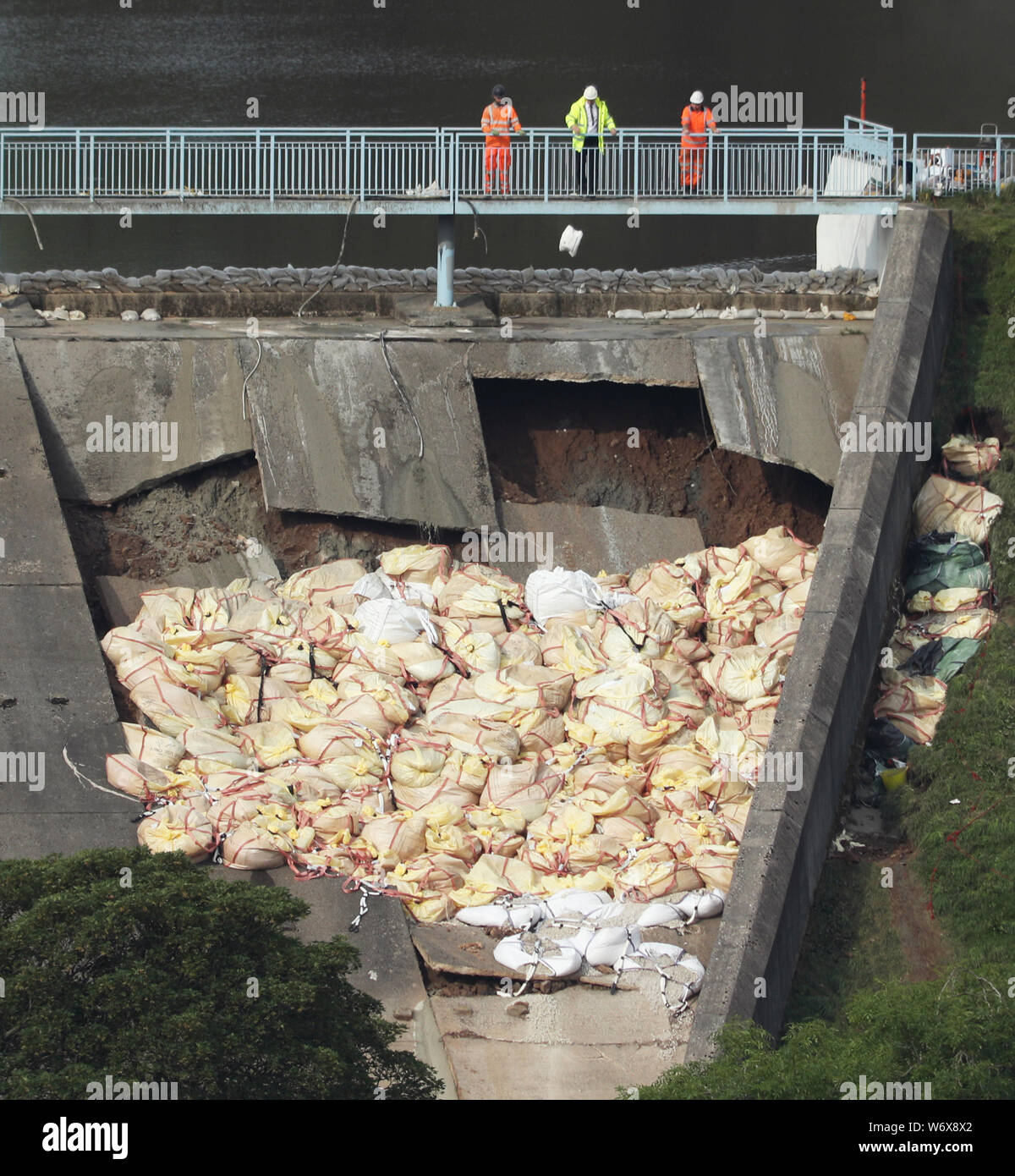 Un sac de béton est jetée sur le réservoir d'Toddbrook endommagé près du village de Whaley Bridge, Derbyshire, après de fortes pluies. Banque D'Images
