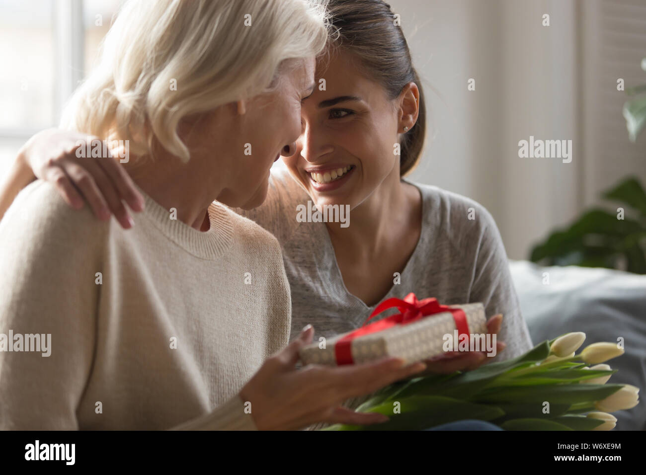 Grandi fille rend présent à la mère d'âge moyen Banque D'Images