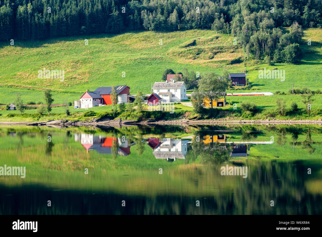 La ferme d'été traditionnel norvégien le long du lac Vangsvatnet reflète dans l'eau près du comté de Hordaland en Norvège Voss Banque D'Images