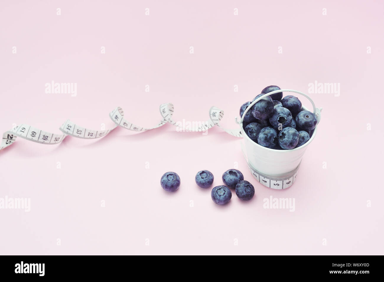 Les bleuets de l'été dans le godet sur fond rose. Petits fruits pour la conception. Close up Vue de dessus ou de mise à plat avec place pour votre texte. Régime alimentaire médical Concept Banque D'Images