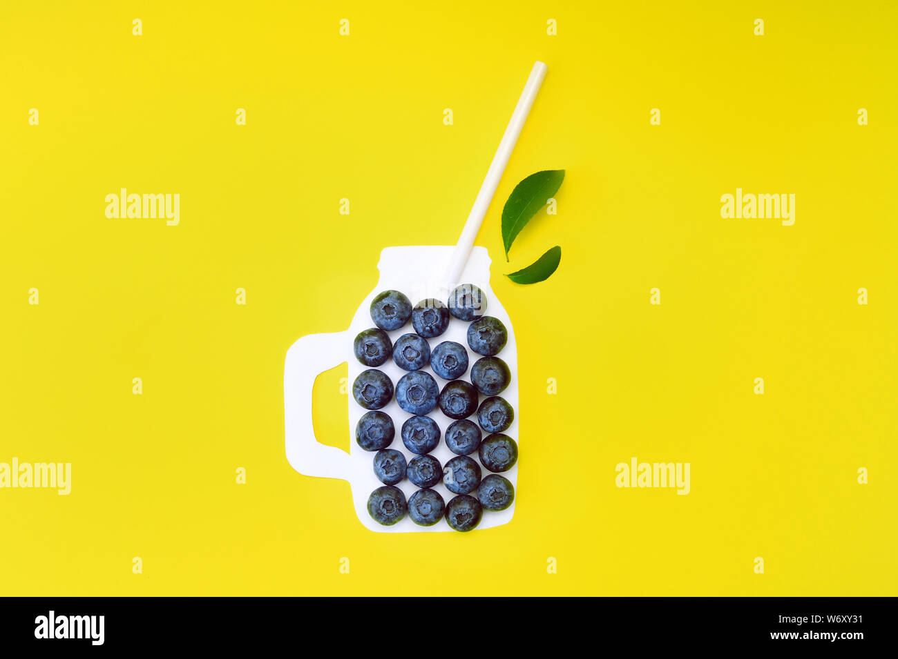 Smoothies d'été avec désintoxication au cassis sur fond jaune. Bordure de baies. Gros plan sur la vue de dessus ou sur une surface plane avec place pour votre texte Banque D'Images