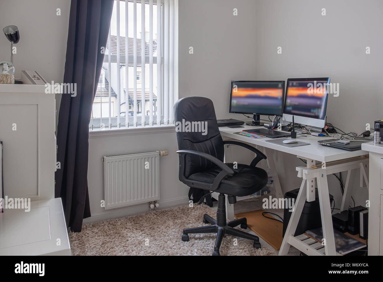 Travailler à partir de Home Office avec 2 moniteurs souris Tablette ordinateur disques durs sur le tableau peint en blanc. Banque D'Images