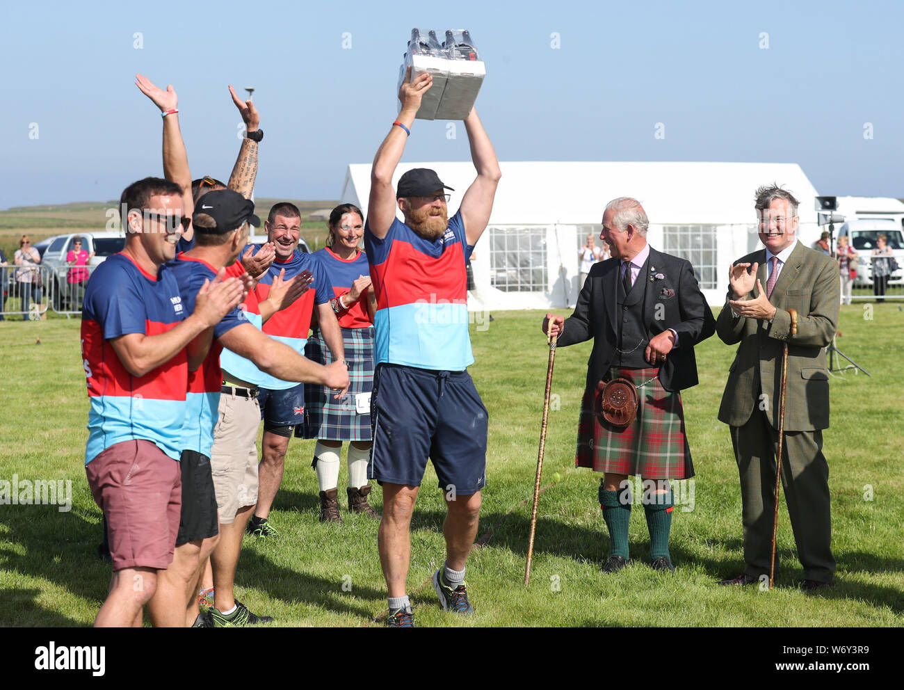 L'aide des héros à la corde avec l'équipe d'une caisse de bière présenté par le Prince de Galles, connu sous le nom de duc de Rothesay tandis qu'en Ecosse (2ème à droite) après avoir battu l'équipe de l'Écosse de la police le Mey Highland & jeux culturels au John O'Groats Showground à Caithness. Banque D'Images