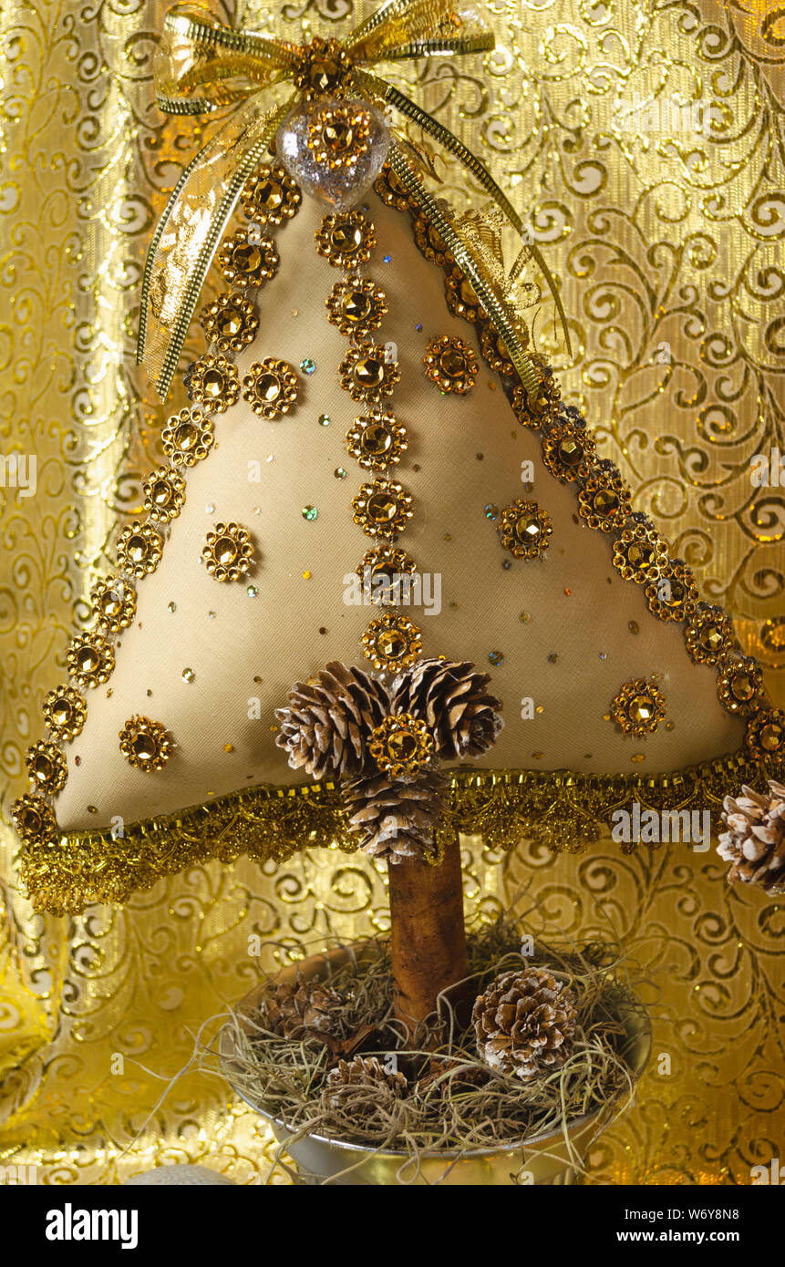 L'arbre de Noël fait main, type coussin orné de pierres, et bow dentelle avec des tons d'or et d'argent, pour la table ou la décoration de la maison Banque D'Images