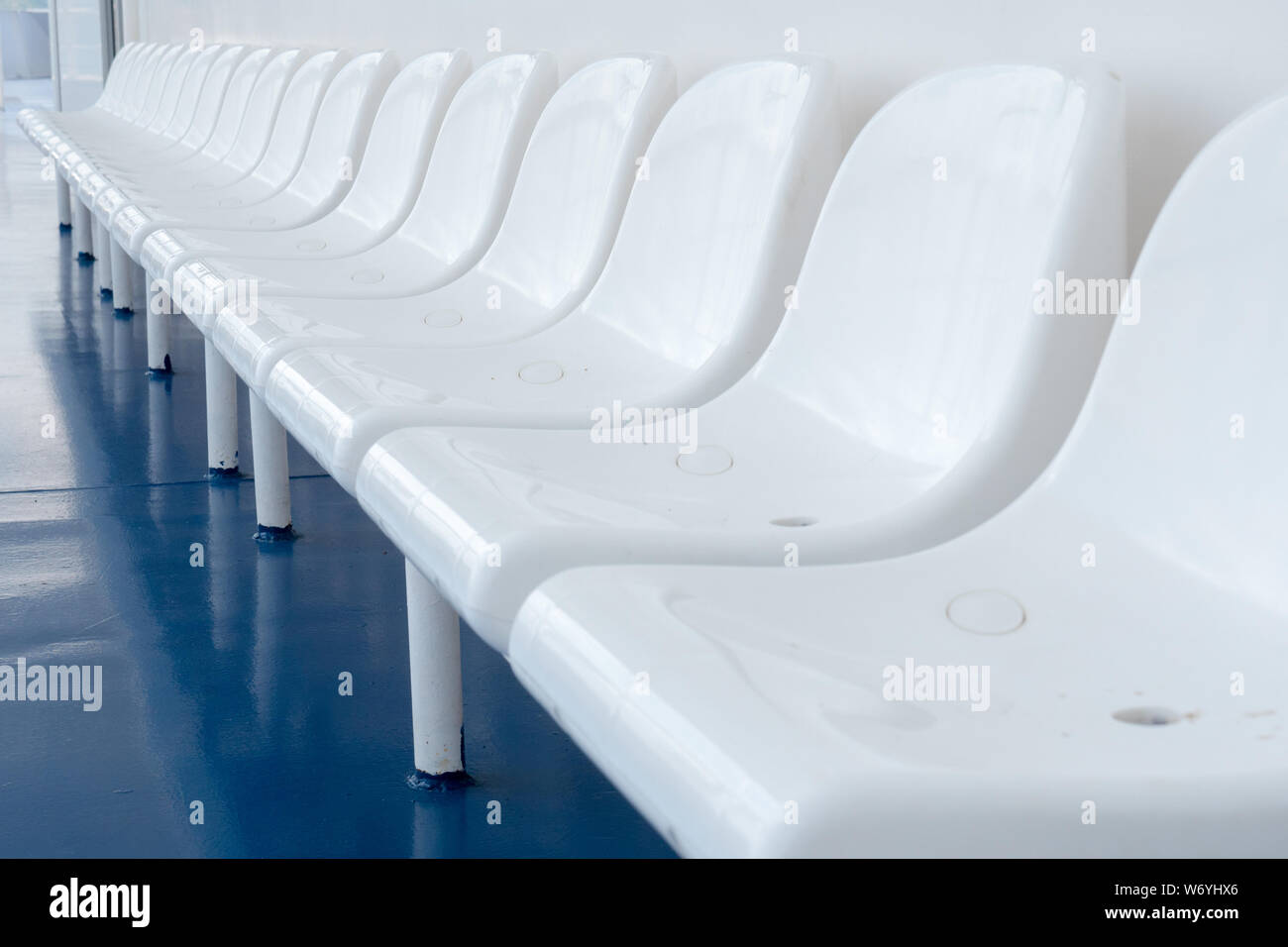 Des chaises en plastique vide sur ferry boat ship liner pour les passagers. Excursion en mer. Bonnes vacances des vacances. Rangée de chaises vides chaises blanches sur bleu-de-chaussée pour les visiteurs au reste des sièges vacants mauvaise saison touristique Banque D'Images