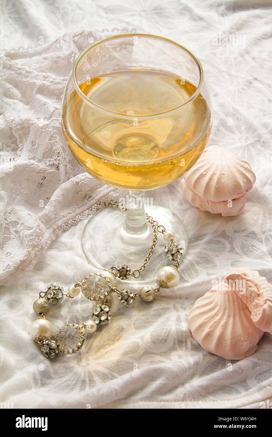 Verre de vin blanc mousseux avec les bijoux et les guimauves. Vue de dessus.Women's day concept Banque D'Images