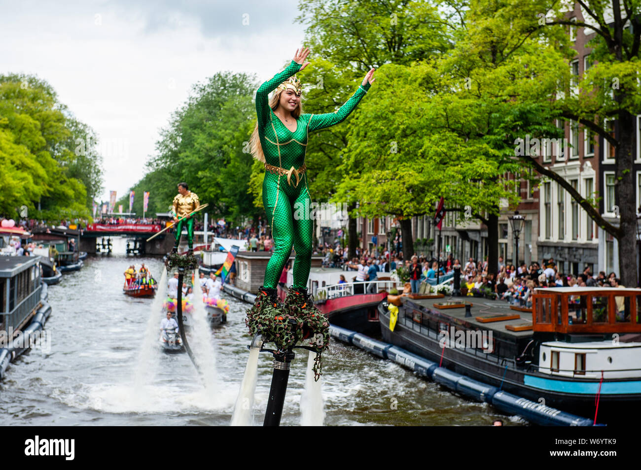 Une femme a vu l'eau-ski au début de la parade.Le Canal Parade est ce qu'Amsterdam Gay Pride est célèbre pour. C'est la couronne sur leurs deux semaines du festival durable que propose plus de 200 événements. Les bateaux commencent à la scheepvaart Museum à la partie est du centre-ville vers la rivière Amstel. Les flotteurs continuer à partir de là prendre le Prinsengracht vers la Westerdok. Le canal Parade commence autour de 12h30 et prend tout l'après-midi. Environ 80 bateaux de différentes organisations et les organisations à but non lucratif participent à l'événement. Banque D'Images