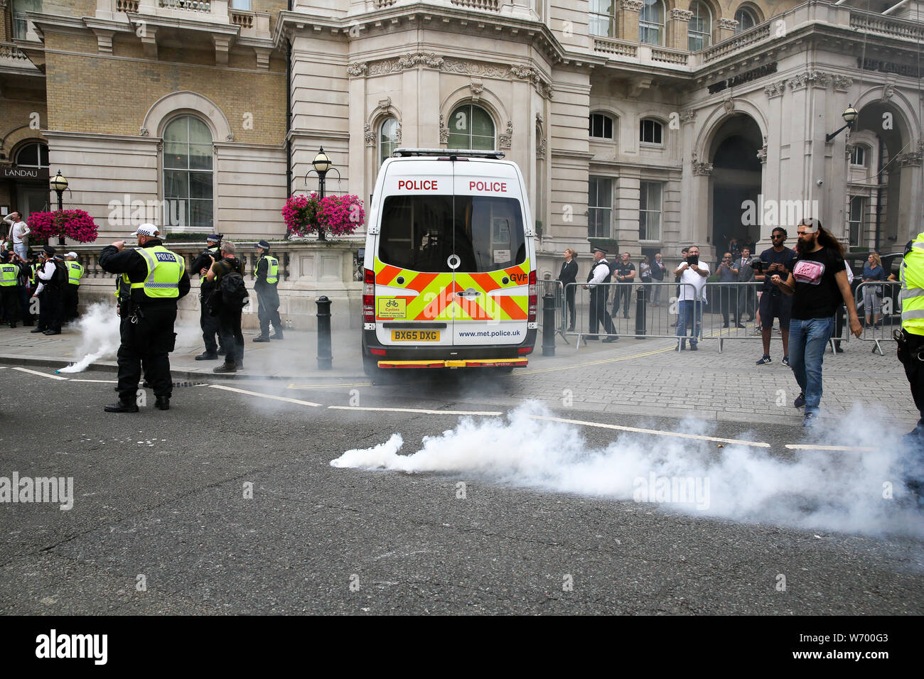 Des contre-manifestants de Arrêter Tommy Robinson et résister au racisme se fumigènes vers les policiers pendant la manifestation.un rassemblement à l'appui de l'extrême droite britannique Stephen Yaxley-Lennon, également connu sous le nom de Tommy Robinson, au centre de Londres. Tommy Robinson a été emprisonné le 11 juillet 2019 à Old Bailey pour outrage au tribunal. Banque D'Images