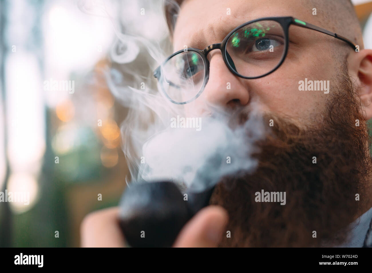 Portrait de l'homme assis et fumer pipe. Banque D'Images