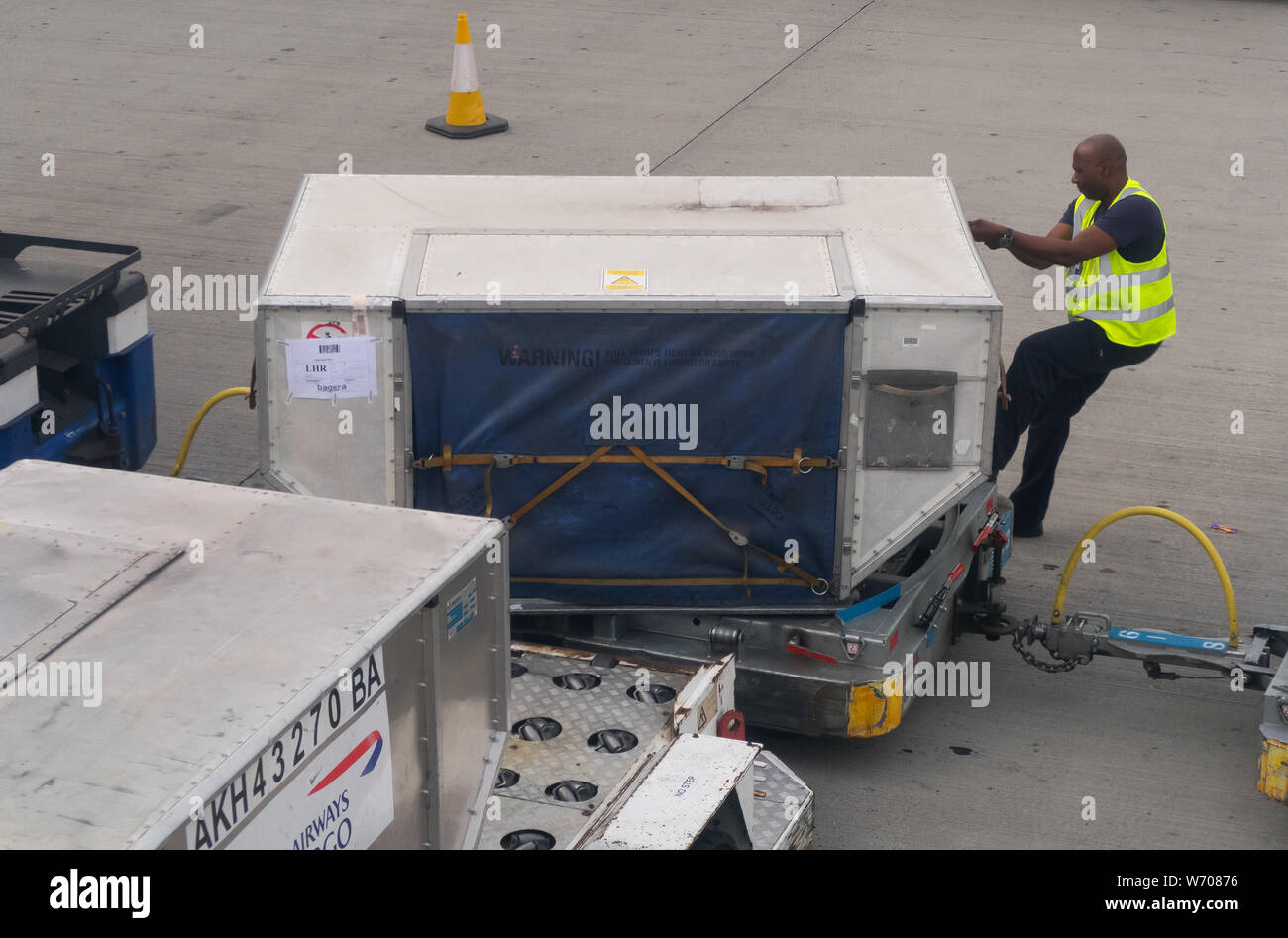 Gauchers bagages décharger vos bagages les conteneurs de fret à partir d'un  avion de British Airways à Londres Heathrow Terminal 5 Photo Stock - Alamy