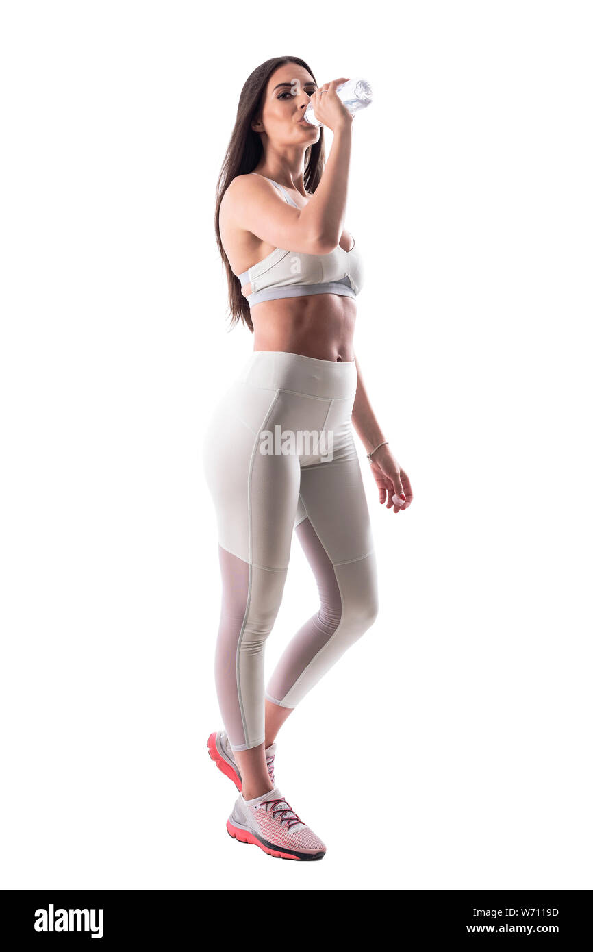 Jeune femme sport fatigué fit l'eau potable de la bouteille en plastique. Corps plein isolé sur fond blanc. Banque D'Images