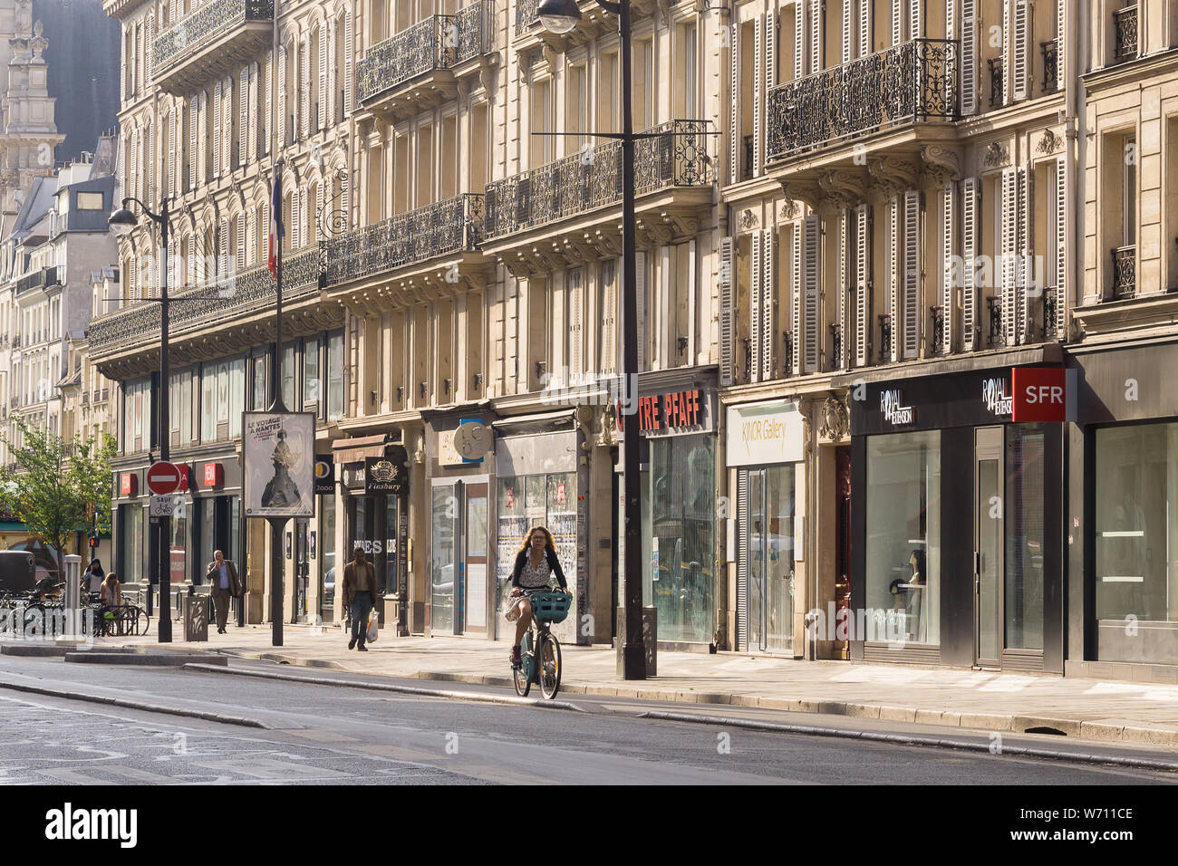 Femme de la rue Paris à vélo - matin scène de rue sur la Rue de Rivoli dans le quartier du Marais à Paris, France, Europe. Banque D'Images