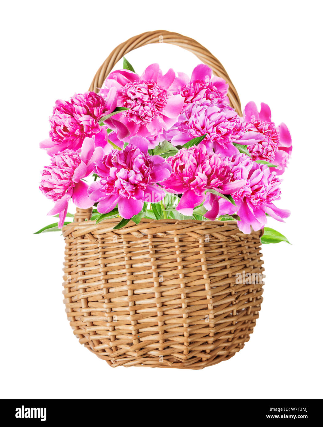 Panier en osier naturel de caronculée été belle avec bouquet de fleurs de pivoines rose nombreux avec des feuilles vertes, isolé sur un fond blanc, v Banque D'Images