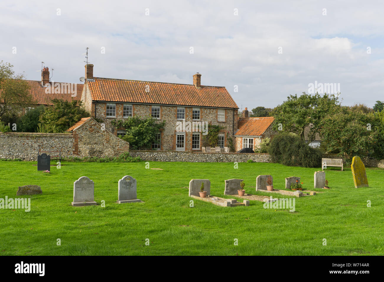 Maison individuelle en briques et silex, maison vue depuis l'église de Tous les Saints dans le village de Morston, Norfolk, UK Banque D'Images
