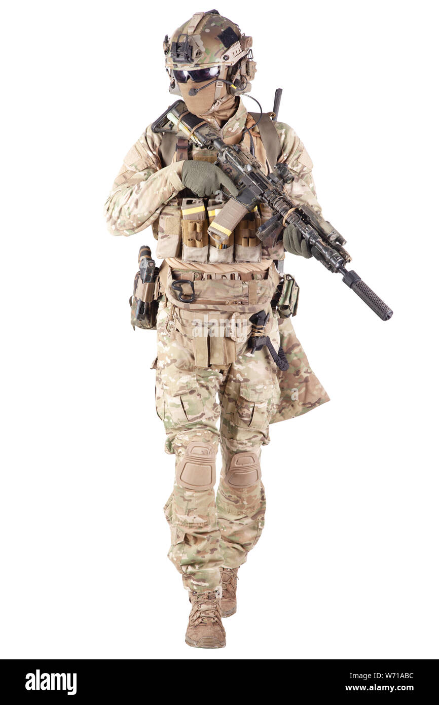 Passionné de Strikeball en chemise à carreaux portant des munitions militaires, un masque facial, un casque et un casque radio, des lunettes tactiques, un pantalon de camouflage, un fusil de service armé et un studio de tir à main isolé sur blanc Banque D'Images