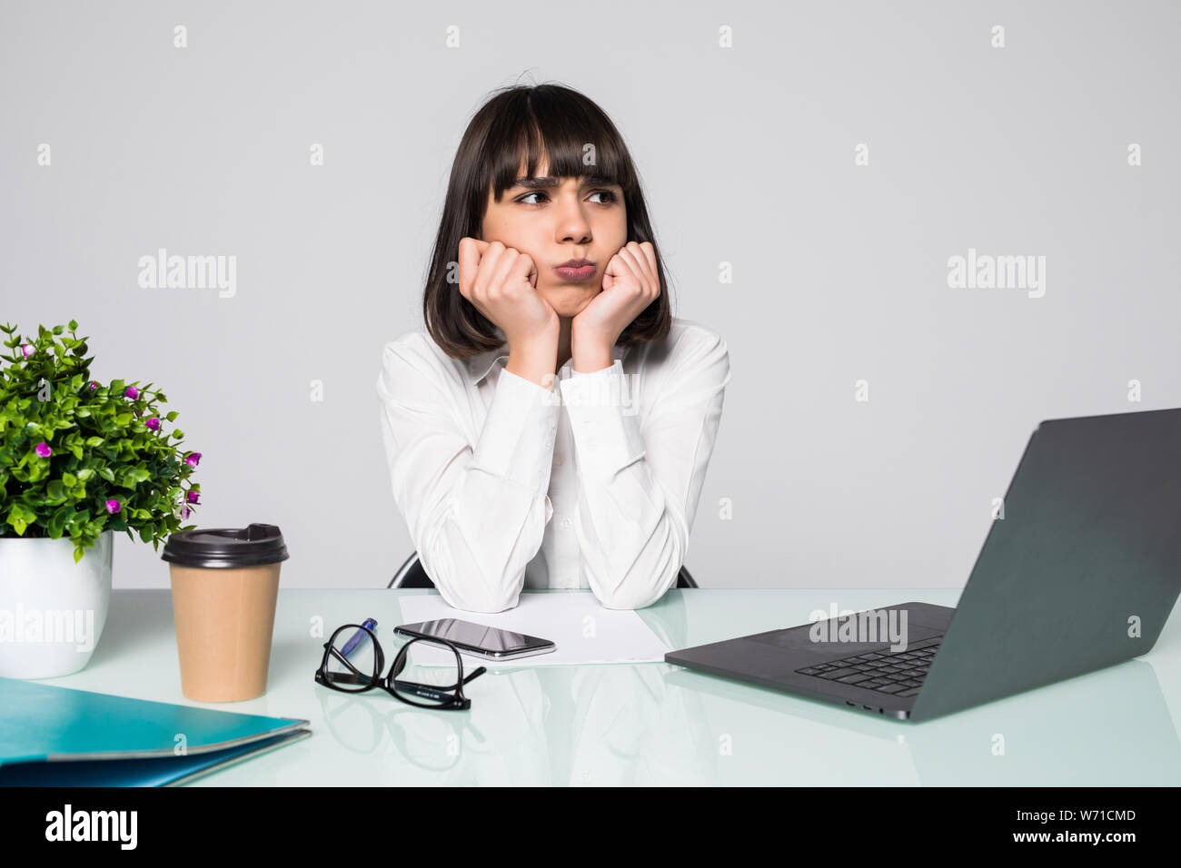 Bored femme dans le bureau avec un ordinateur portable et à regarder l'écran d'ordinateur Banque D'Images