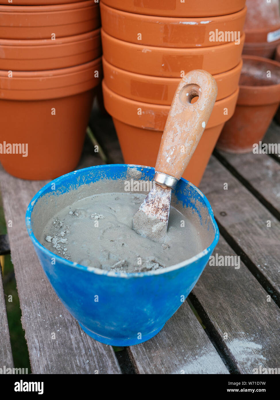 Rendre le système d'irrigation des pots en argile à l'aide de pots de terre cuite émaillée. Le mélange de ciment à carrelage. Banque D'Images
