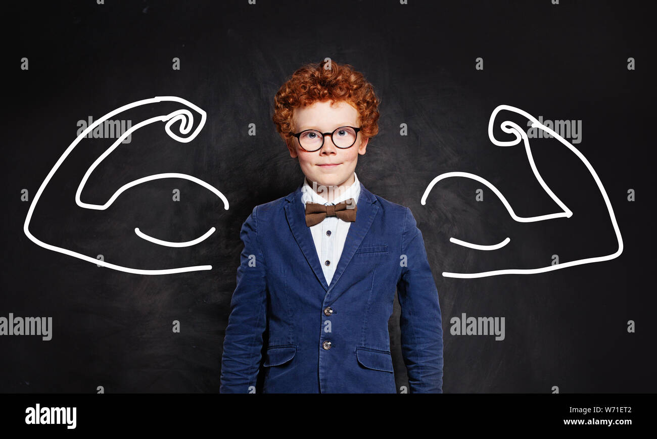 Portrait d'une enfant avec de gros biceps muscle on blackboard Banque D'Images