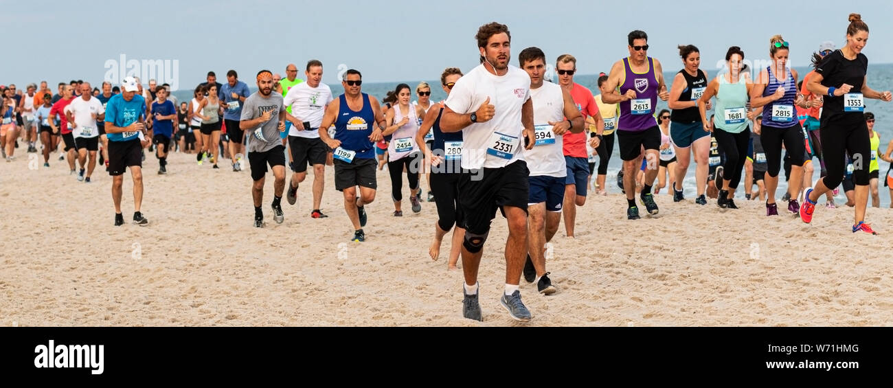 Babylon, New York, USA - 24 juin 2019 : Beaucoup de personnes exécutant une course de 1,6 km sur la plage par l'eau à l'état d'été Robert Mousses Parcs série. Banque D'Images