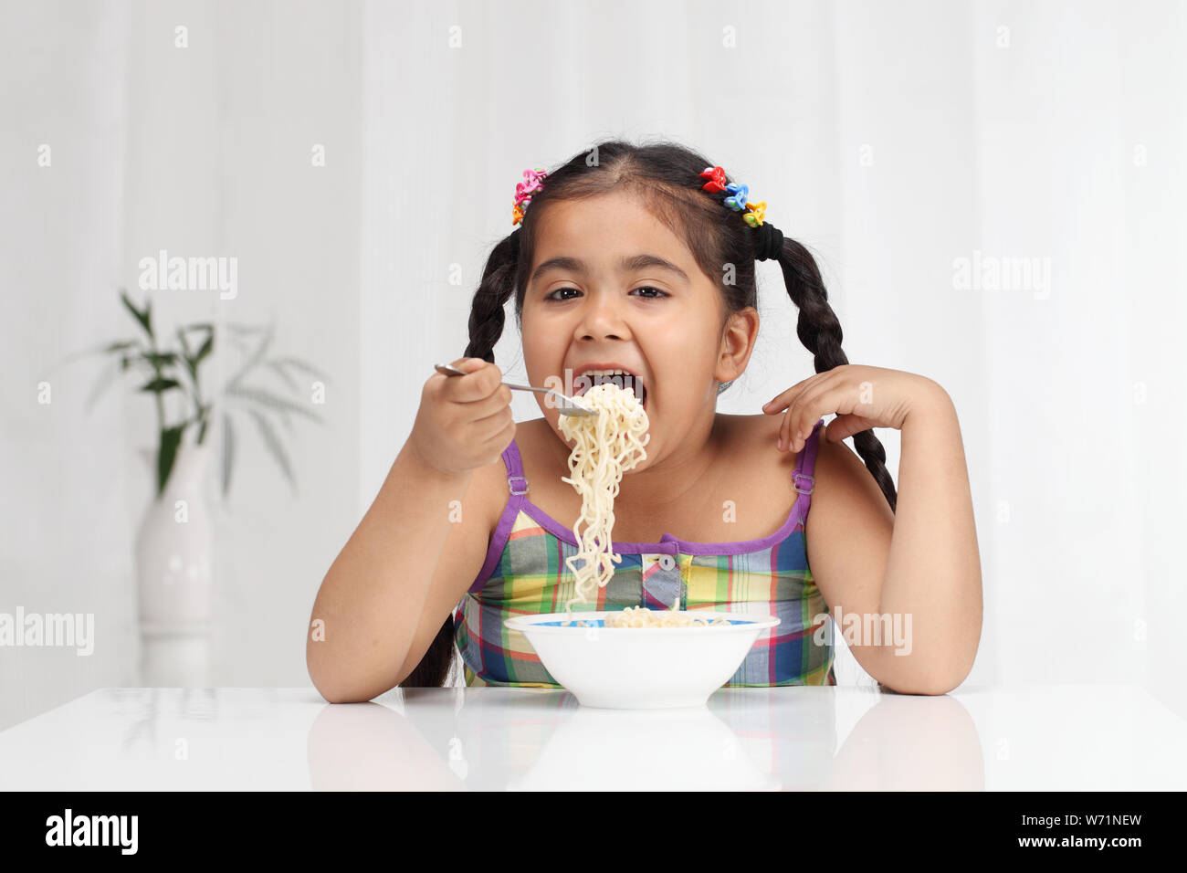 Girl eating noodles Banque D'Images