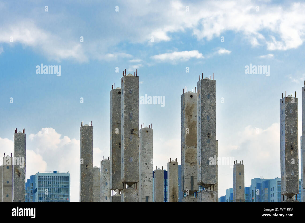 Des colonnes de béton armé verticale avec les armatures at Construction Site, fini les immeubles à appartements, Ciel et nuages en arrière-plan. L'immobilier, Habiter Banque D'Images