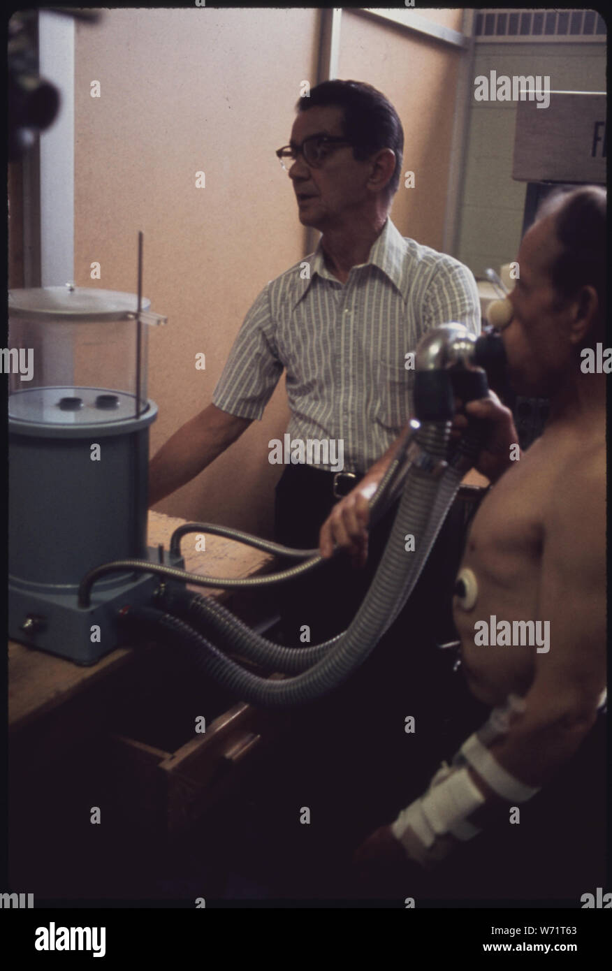 Un TECHNICIEN DU LABORATOIRE DANS LE POUMON NOIR APPALACHIAN REGIONAL HOSPITAL À BECKLEY, WEST VIRGINIA, surveille un mineur dont la capacité pulmonaire est à l'essai. Des échantillons de sang sont également prises et son rythme cardiaque est surveillée EN MARCHANT SUR UN TAPIS ROULANT CES ET D'AUTRES MÉTHODES D'ESSAI CONNUS SONT UTILISÉS POUR DÉTERMINER SI LES PARTICULES DE POUSSIÈRE DE CHARBON, les mineurs ont dans leurs poumons qui provoquent un essoufflement progressif Banque D'Images
