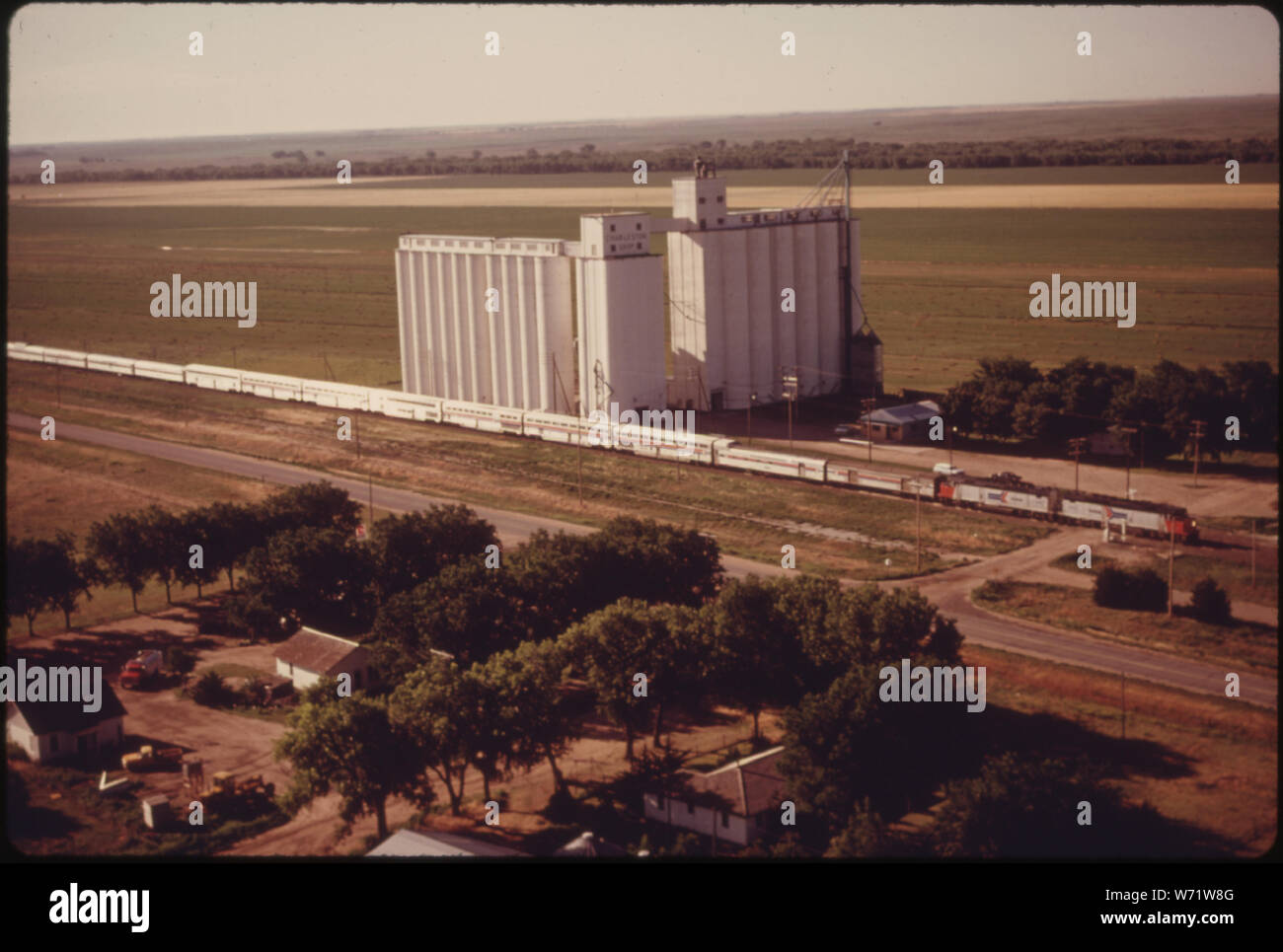 Vue aérienne DU SUD-OUEST DE LIMITED (TRAIN # 3) LORSQU'IL PASSE UNE FERME COOPÉRATIVE ASCENSEUR ENTRE VILLE ET JARDIN Dodge City, KANSAS, DANS LA PARTIE SUD-OUEST DE L'État. Les silos à grains, comme ce petit carrefour ET LES COLLECTIVITÉS SONT TYPIQUES DE CETTE ZONE AGRICOLE. Les voyageurs d'AMTRAK TRAIN VOYAGE ENTRE LOS ANGELES ET CHICAGO Banque D'Images