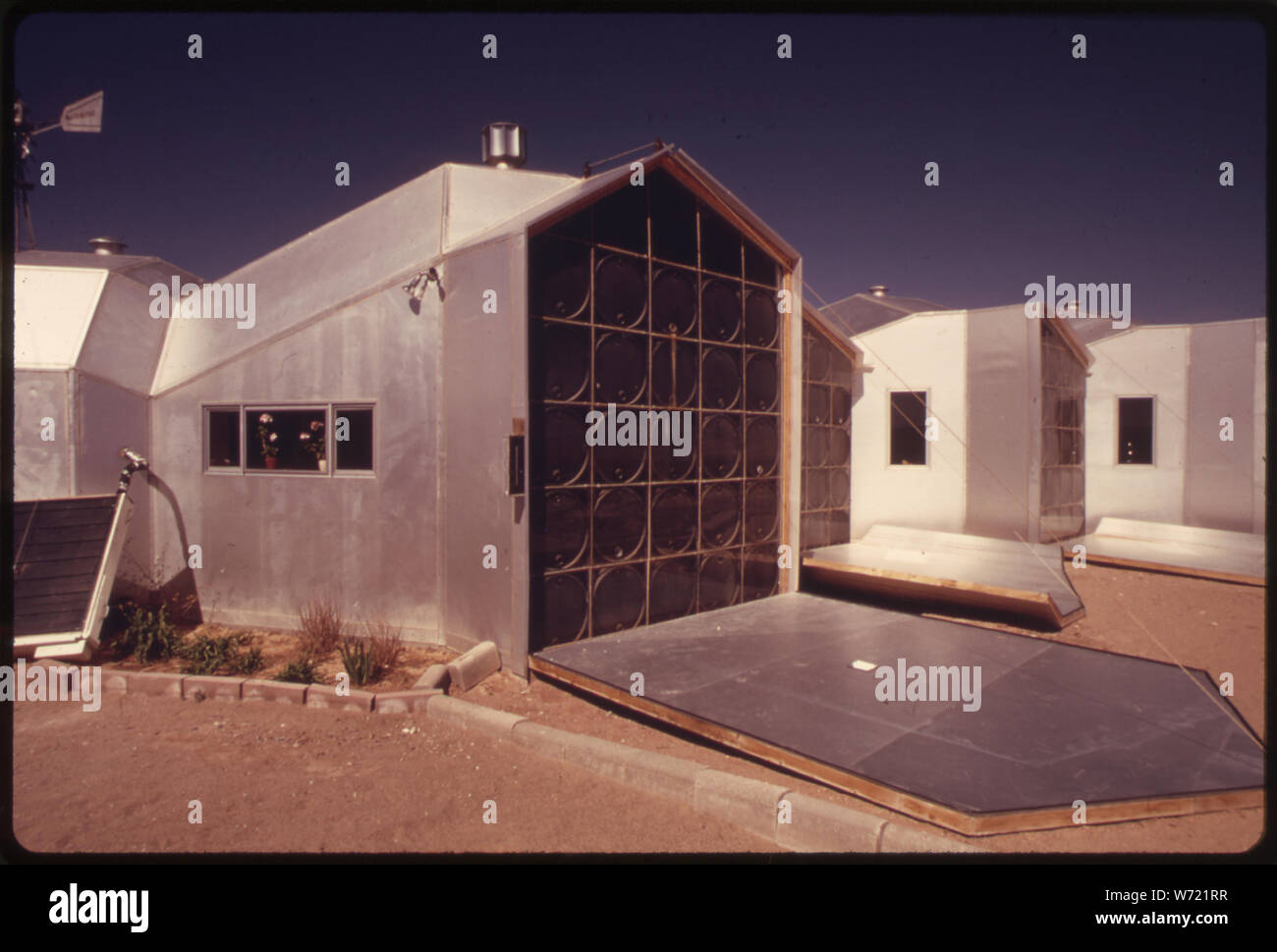 Près d'UN PANNEAU DE CHAUFFAGE SOLAIRE DANS UNE MAISON MODULAIRE CONSTRUIT PRÈS DE CORRALES, NEW MEXICO. Fermé la nuit, LE GROUPE TOMBE PENDANT LA JOURNÉE POUR PERMETTRE AUX RAYONS DU SOLEIL DE PASSER À TRAVERS LA VITRE ET noirci de chaleur 55 GALLONS REMPLIS D'EAU Banque D'Images