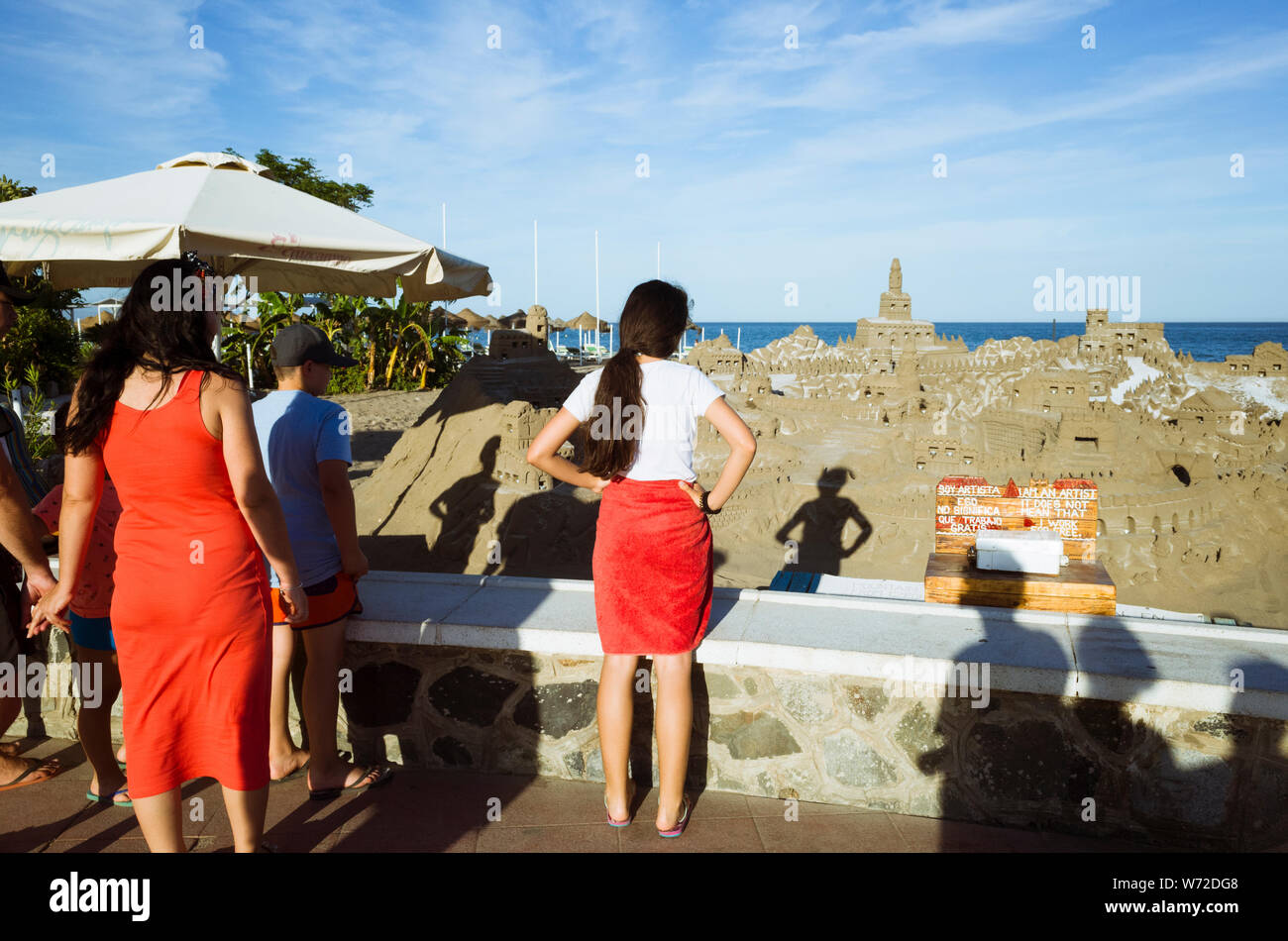 Torremolinos, la province de Malaga, Andalousie, Espagne : les touristes regarder un grand château de sable sur la plage Playamar. Un petit village de pêche jusqu'à la fin des 50' il Banque D'Images