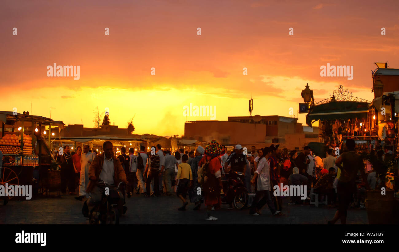 Foule de visiteurs sur Jem El Fna dans les rayons du soleil couchant Banque D'Images