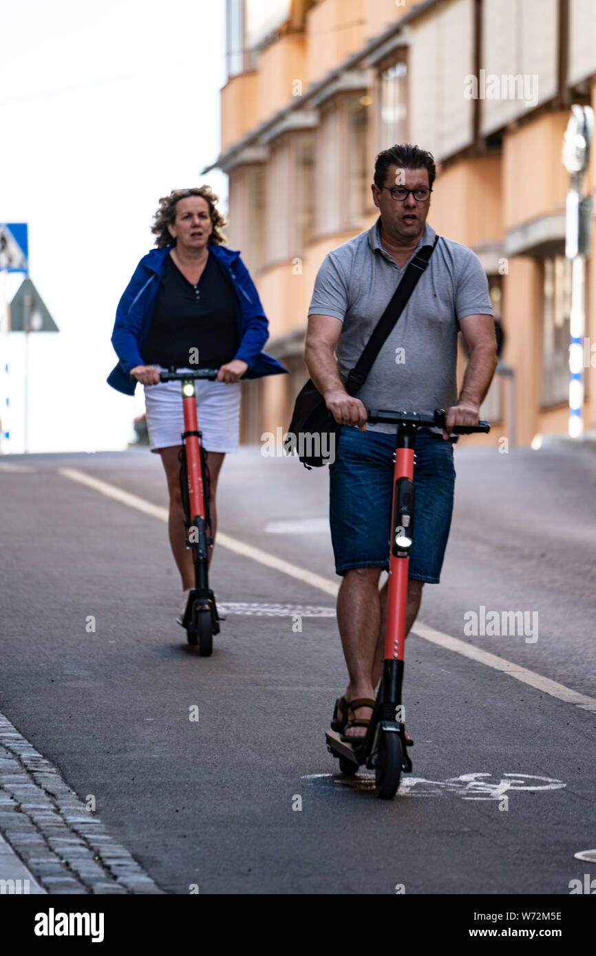 Les personnes qui utilisent des scooters électriques dans une ville (Stockholm, Suède). Banque D'Images
